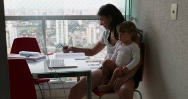 Mother working at home holding baby toddler infant boy