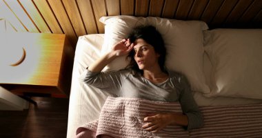 Anxious single woman in bed suffering before sleep