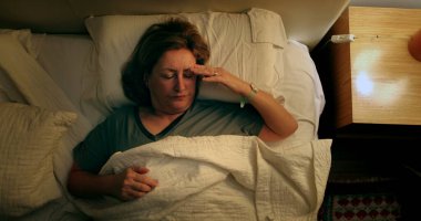 Sleepless Older woman turns light ON suffering from insomnia
