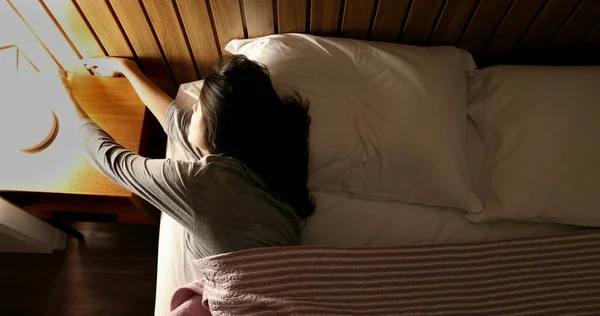 Woman Bed Turning Nightstand Light — Stockfoto