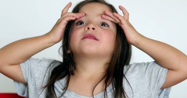 Little girl grimacing, sticking ongue out. Child grimace making funny faces