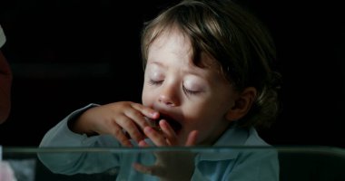 Toddler grabbing cookie. Baby boy grabs food from table
