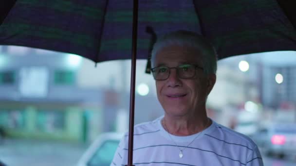 Homem Idoso Caminhando Rainy City Sidewalk Com Guarda Chuva Sorrindo — Vídeo de Stock