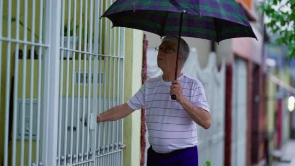 Oudere Man Komt Thuis Terwijl Het Regent Opent Poort Sluit — Stockvideo
