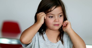 Tired little girl rubbing eyes with hands