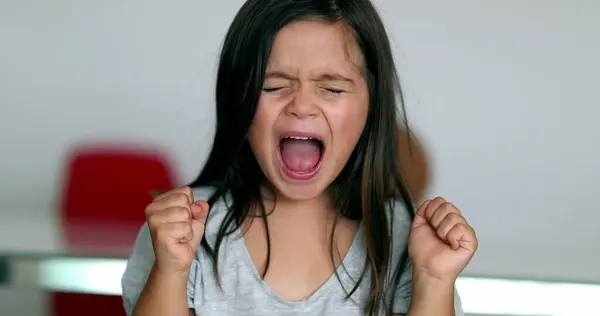 Upset little girl yelling feeling angry