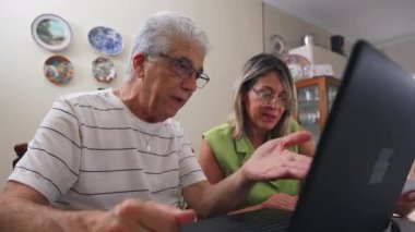 Ev Mutfağı 'nda dizüstü bilgisayarın önünde mali zorluklar hakkında tartışan yaşlı çift üzgün.