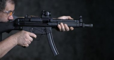 Yüksek hızda ateş ediliyor, HK SP5K GUN yan görüşü. Alman saldırı tüfeğini hedef alan ve ateş eden kişi