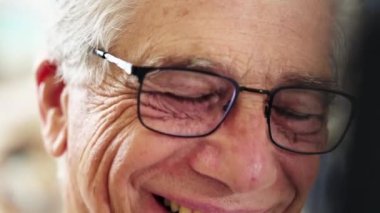 Mutlu bir son sınıf öğrencisinin yakın çekimi. Gülüyor ve gülümsüyor. Dost canlısı bir gözlüğü var.