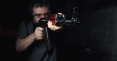 Kalaşnikov 'a nişan alan adam süper yavaş çekimde 800 fp, AK-47 ön görüş açısıyla ateş ediyor.
