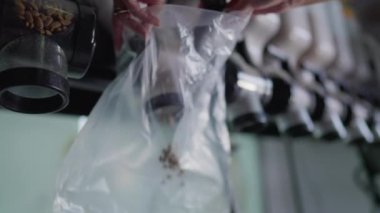 Pet Shop 'ta köpek maması dağıtımı: Uygun mısır gevreği dağıtıcısından elle doldurulmuş plastik torba