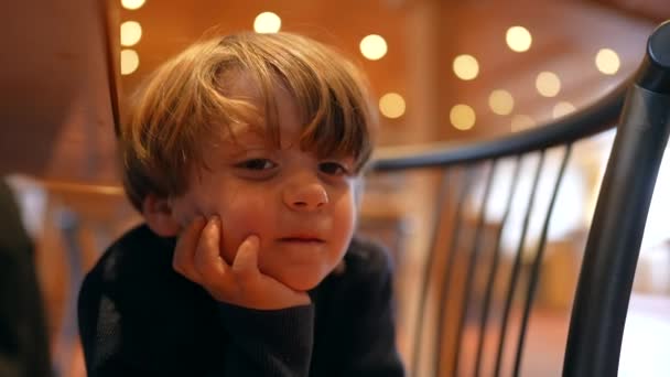 快乐男孩手托着下巴坐着 耐心地在餐馆里等饭的饥饿感 — 图库视频影像