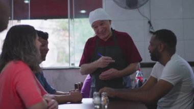 Geleneksel Güney Amerika Kafeteryasından müşteri siparişi alan, Restoran Hizmeti 'nde müşterilere yardım eden kıdemli garson.