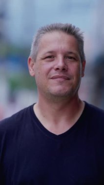 Dikey video kameraya bakan 40 'lık bir adamın portresi.