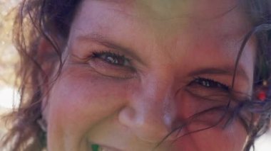 Neşeli orta yaşlı kadın kameraya gülümsüyor Makro yakın plan rüzgar süpürgesi gibi saçları var