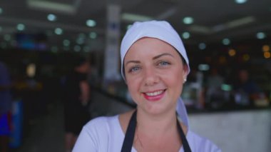 Kafeterya işinin önünde kendine güvenen mutlu genç bir kadın. İş yerinde üniforma giyen bayan garson. iş kavramındaki insanlar