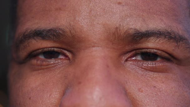 真剣な中立的な表現を持つ1人の黒人のマクロの目を閉じ カメラの極端な詳細を見る — ストック動画
