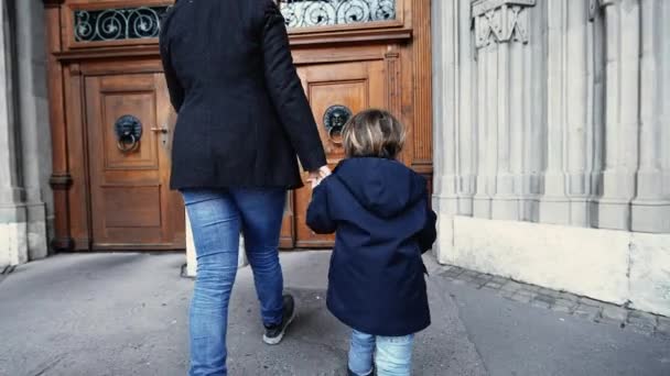 ドアノブのために到達し 木製の伝統的なドアに開く宗教寺院に手を握る母と子供 — ストック動画
