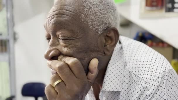 発見されたゲイズ 灰色の髪を持つ高齢アフリカ系アメリカ人のクローズアップ カウンターで反射 — ストック動画