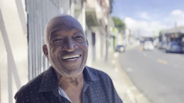 Sorriso Ensolarado Homem Sênior Preto Sorridente Gosta Sombra Calçada Brasileira — Vídeo de Stock