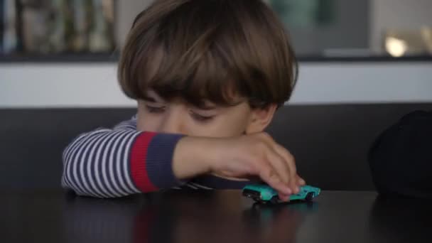 Hyper Aktiva Barn Leker Med Leksaksbil Toppen Bordet Närbild Ansikte — Stockvideo