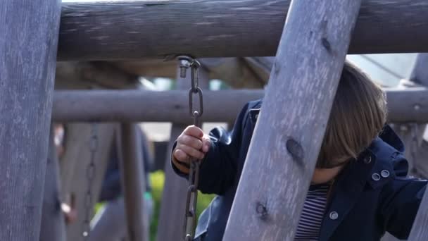 Fokuserat Barn Navigera Playground Bridge Hålla Metallkedjor Och Trampa Träplankor — Stockvideo