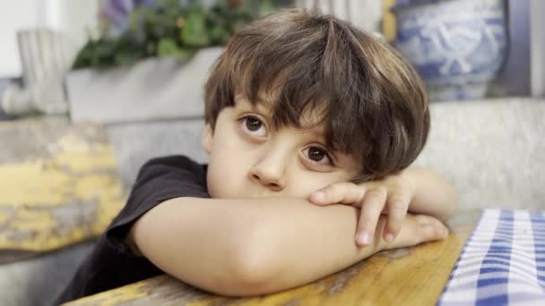 Κουρασμένο Παιδί Leans Στο Τραπέζι Βαθιά Στη Σκέψη Προβληματική Στιγμή — Αρχείο Βίντεο