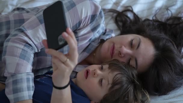 Entspannte Mutter Und Sohn Schlafanzug Telefonieren Bett Offener Häuslicher Moment — Stockvideo