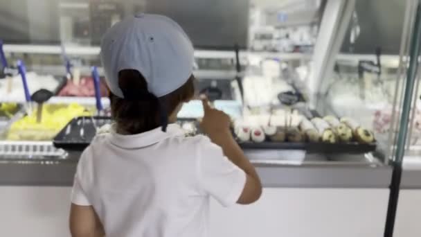 Junger Junge Süßwarenladen Zeigt Auf Gläserne Theke Zeigt Seiner Mutter — Stockvideo