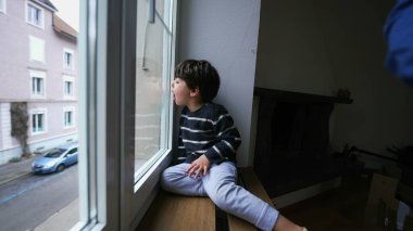 Pencerenin kenarında oturup camlara üfleyerek buhar çıkaran çocukların hayalleri. Küçük çocuğun merakı ikinci kattan gözlemliyor.