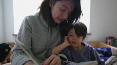 Anne 'den Küçük Çocuğa Kitap Okuma Başucunda Oturuyor, Çocuk Hikayeye dalmış, Annelik Yaşamında Nişanlı Ebeveynlik Sahnesi