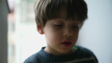 Dalgın, küçük çocuk, yakın çekim yüzü. Derin düşüncelere dalmış bir çocuk.