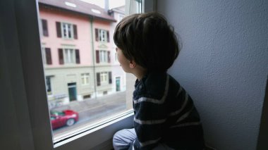 Çocuk ev penceresinden nefes alıp veriyor. Yoğunluk yaratıyor. Sıkıcı çocuk içeride kilitli kalıyor.