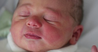 First day of life of newborn infant baby falling asleep