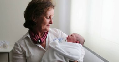 Grand-mother holding newborn baby in arms