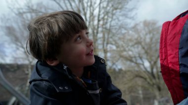 Çocuk sonbahar ya da sonbahar sezonunda atlıkarınca parkında eğleniyor. Yakın plan beyaz erkek çocuk kavşağın etrafında dönüyor mutluluk ve heyecan hissediyor.