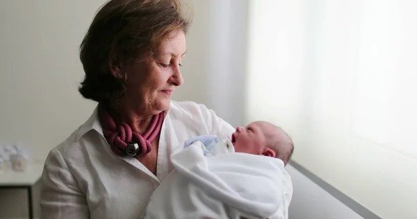 Grand-mother holding newborn baby in arms