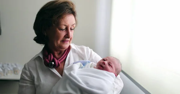 Grand-mother holding newborn baby infant grand-son