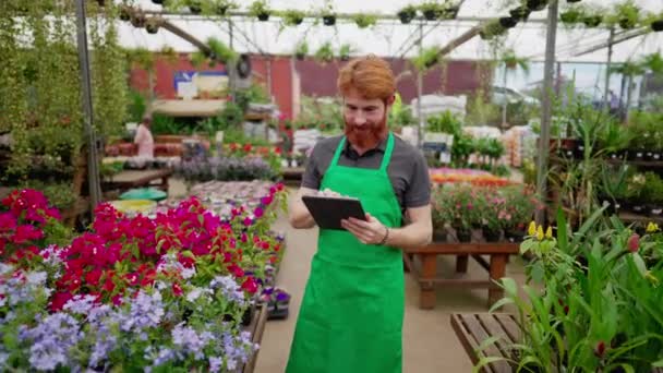 Smiling Red Haired Employee Tablet Flower Shop Hombre Joven Delantal — Vídeos de Stock