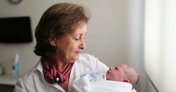 Grand-mother holding newborn infant baby in arms