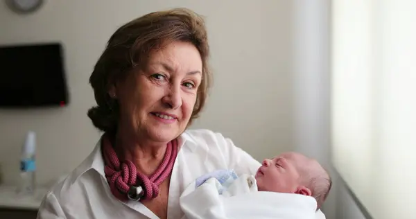 Grand-mother holding newborn infant baby in arms