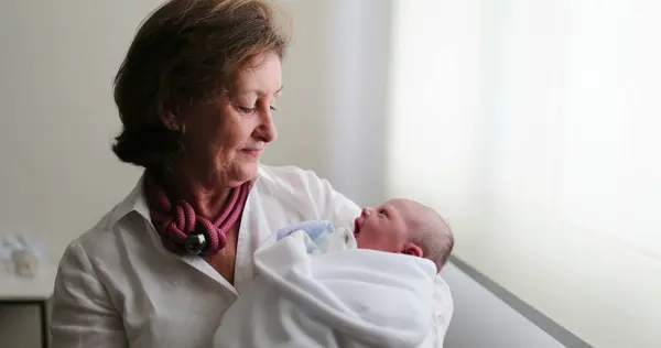 Grand-mother holding newborn baby in arms