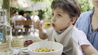 Çocuk, Anne 'nin Açık Hava Restoranında Kucağına Oturuyor Geleneksel İtalyan Sıcak Makarnası Serinletiyor