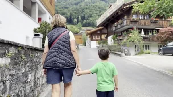 Friedliches Gehen Oma Und Junge Der Ruhigen Strasse Schweizer Alpendorf — Stockvideo
