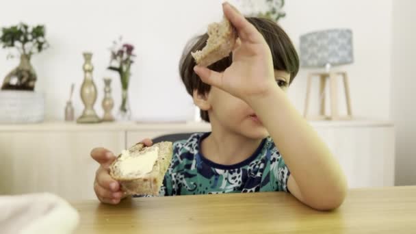 テーブルで朝食のための子供の救世主バターパン — ストック動画