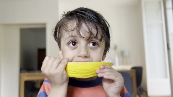 午後のスナックの間に黄色いメロンで誘導する幸せな子供 ジュースで覆われた手食い — ストック動画