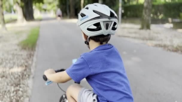 パークサイクリングの不均衡 ヘルメットの男の子は バランスを失い サイクリストのグループとしての焦点を渡す — ストック動画