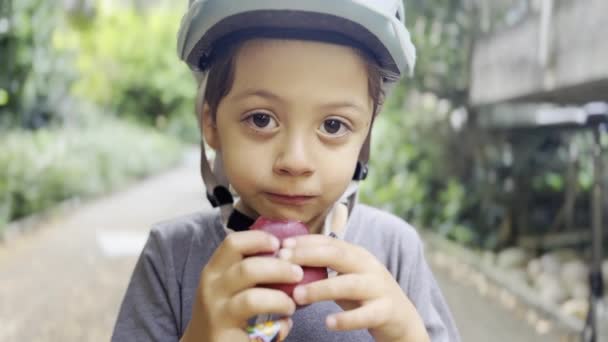 Healthy Snack Park Boy Stands Bike Helmet Enjoying Plum Snack — Stock Video