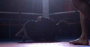 Boks dövüşçüsü yere düştükten sonra ayağa kalkar. Boksör kendini süper yavaş çekimde çarpışmaya hazırlıyor 800 fps hızla rampa ile