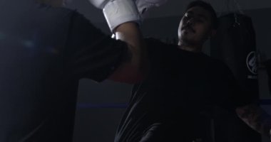 Avcı 800 fps 'de süper yavaş çekimde yakalanan rakibine vuruyor. Boks ringinde tekmeleyen adam